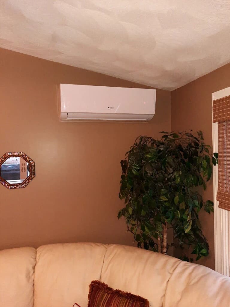 A wall mounted indoor heat pump head installed high on an interior wall