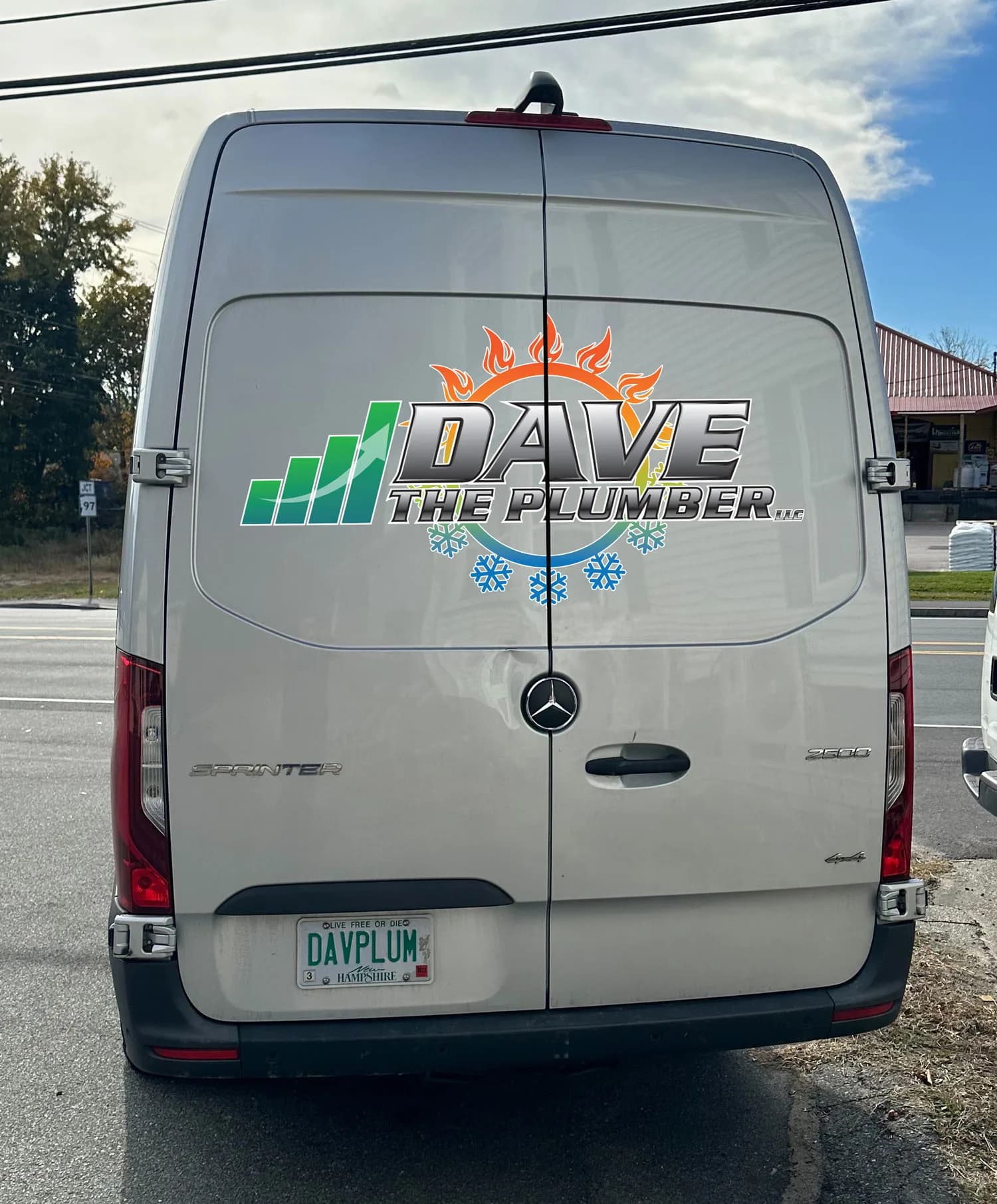 The rear of a branded service van showing the company logo and a New Hampshire registration plate